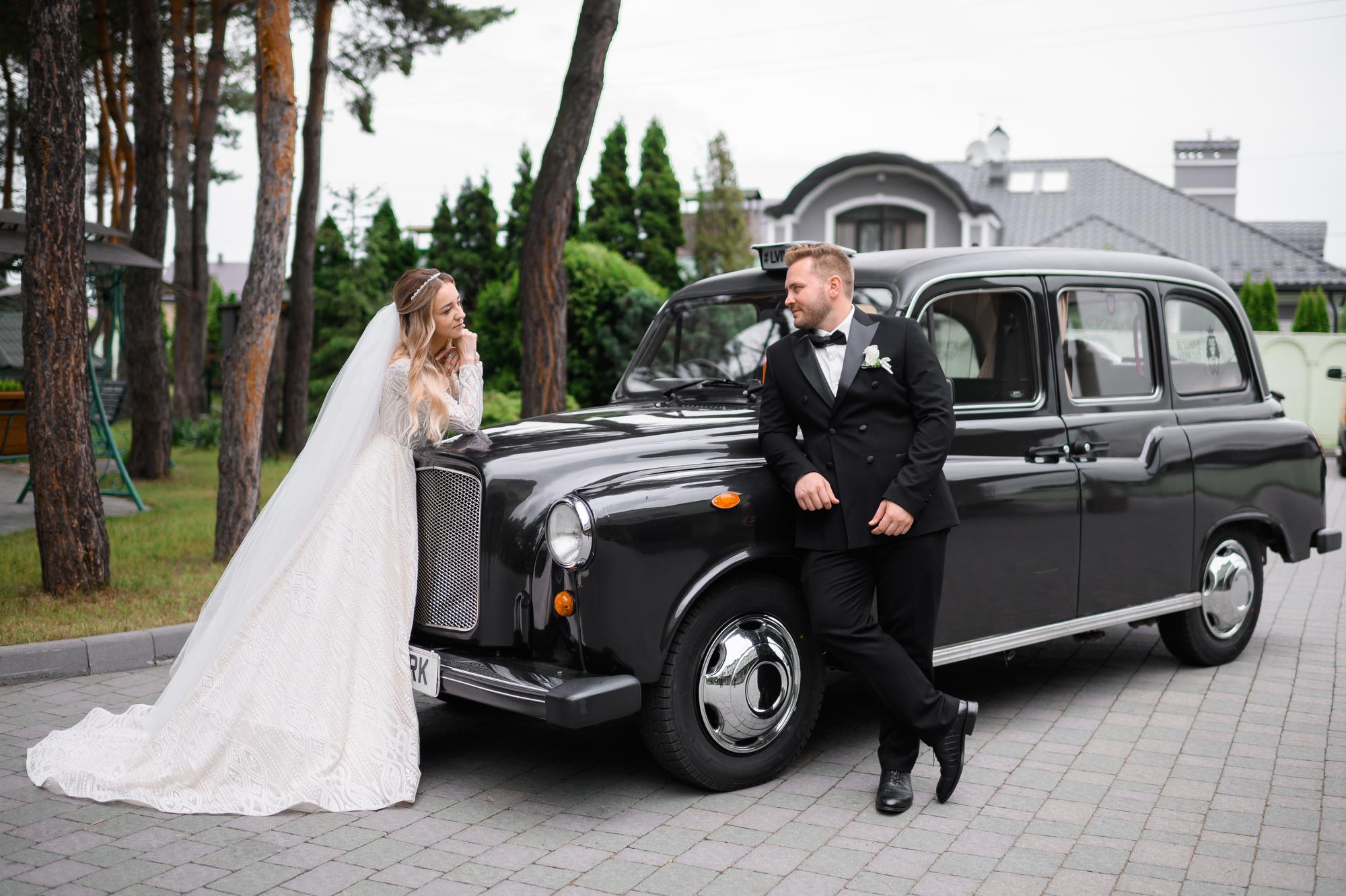 side-view-stylish-handsome-groom-black-tuxedo-leaning-retro-car-looking-bride-which-standing-opposite-lovely-looking-him-wedding-walk-open-air